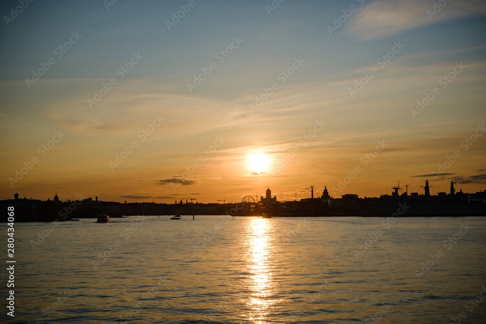 sunset on the sea, city silhouette, golden hour