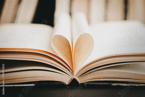 Opened book with heart shaped page. Heart from book page, valentine's day