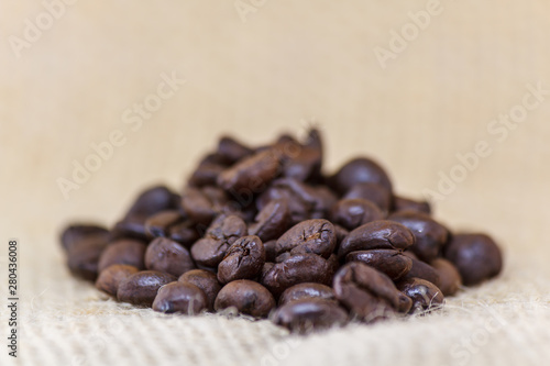 Fototapeta Naklejka Na Ścianę i Meble -  Closeup of roasted black coffee beans on fabric with deep of field