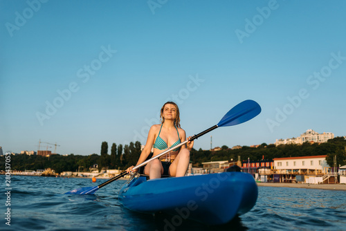 young girl sports figure sit on a kayak to meet the dawn. Lifestyle, sports every day © mtrlin
