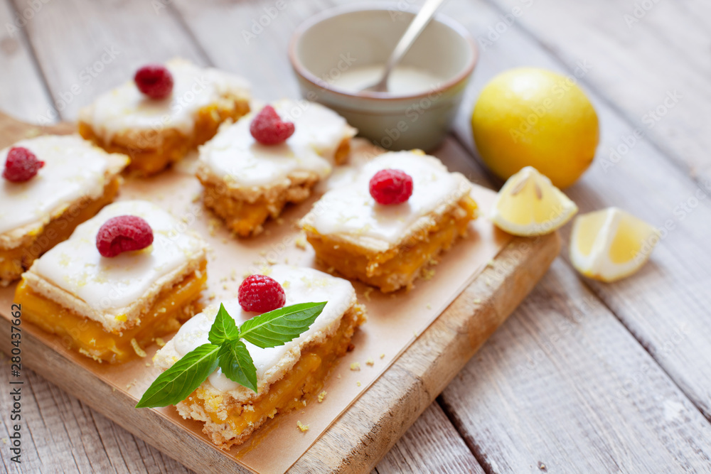 Lemon portion cakes decorated with raspberry and lemon zest Lemon portion cakes decorated with raspberry and lemon zest