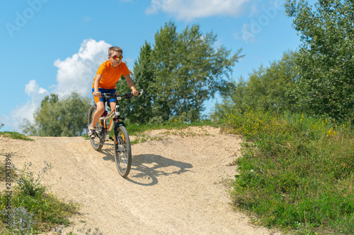 A boy on a mountain bike drives off a hill