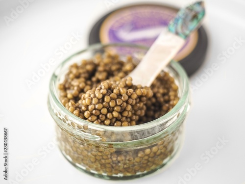 Closeup of golden osetra caviar in a jar with blurred background photo