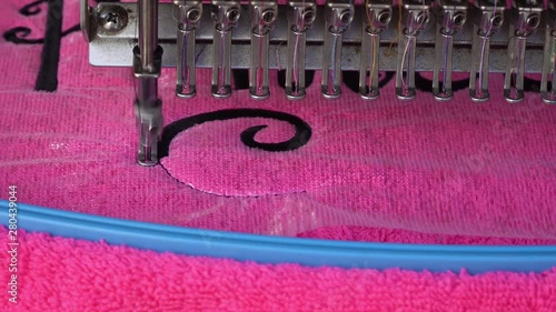 The machine embroider, embroiders a beautiful inscription, a logo on clothing, fabric.