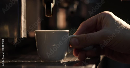 Barista makes a cup of aromatic coffee on a vintage Italian coffee machine.