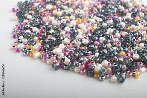 Multi-colored beads.Colorful beads on a wooden surface.It is used in finishing fashion clothes.Variety of shapes and color to make abead necklace or a string of beads toplease a woman of fashion.