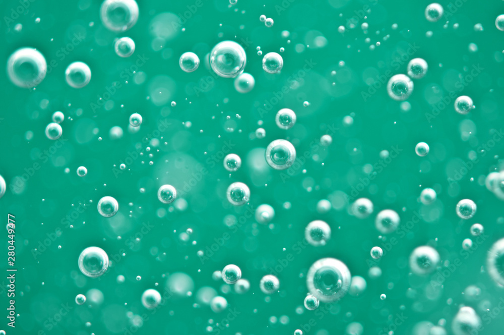 Beautiful turquoise background. Rising air bubbles in clear water. Oxygen. Macro