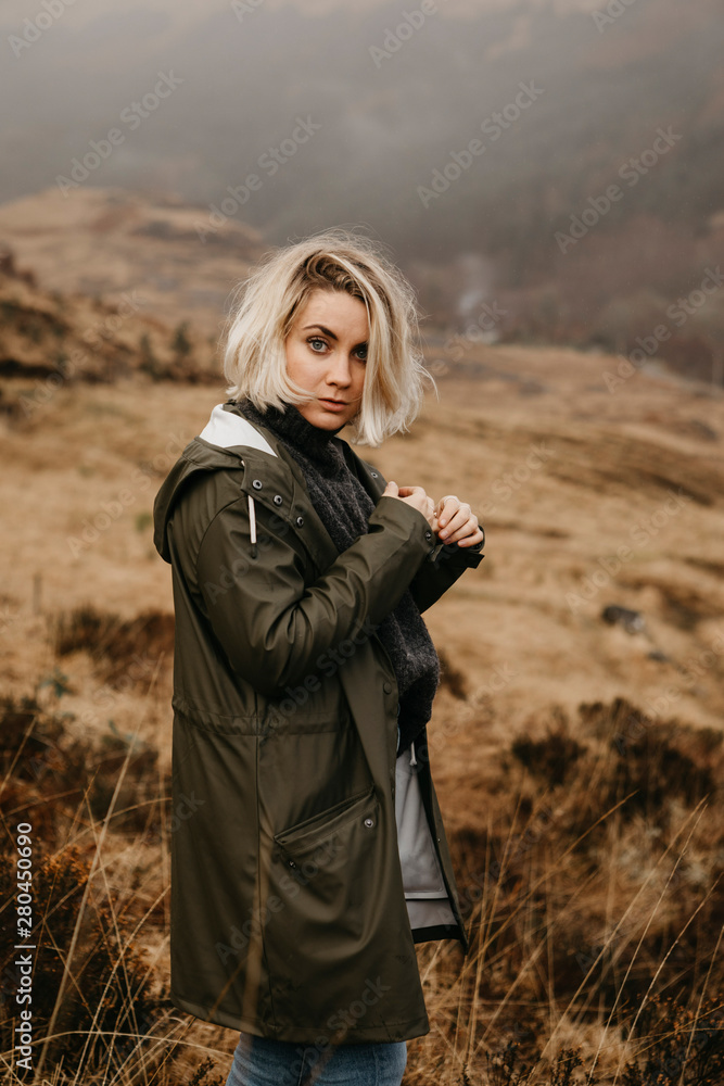 UK, Scotland, Highland, portrait of young woman in rural landscape UK, Scotland, Highland, portrait of young woman in rural landscape