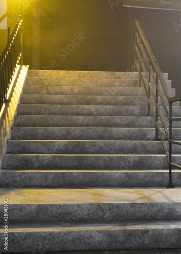 Bright yellow light shining above concrete stairway photo