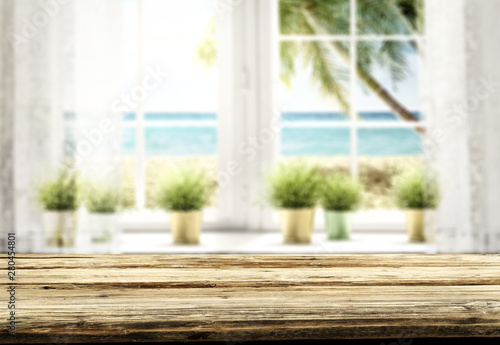 Window and table background with beautiful blue ocean and sandy beach view behind the window. Summer sunny day. Empty space for your decoration and advertising product.