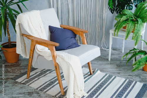 Soft chair with wooden armrests in cozy minimal interrier photo