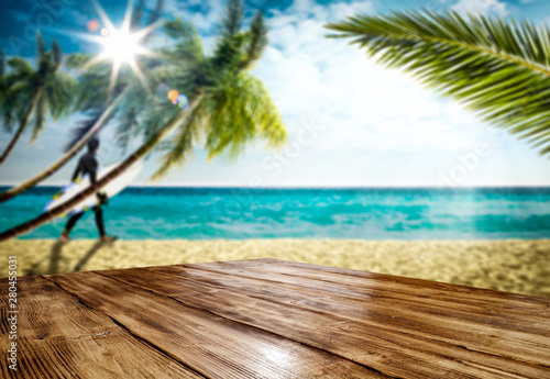 Table background with beautiful blue ocean and sandy beach view. Summer sunny day in distance. 