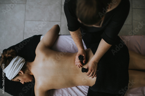 Young woman with sachets on her back during stamp massage photo