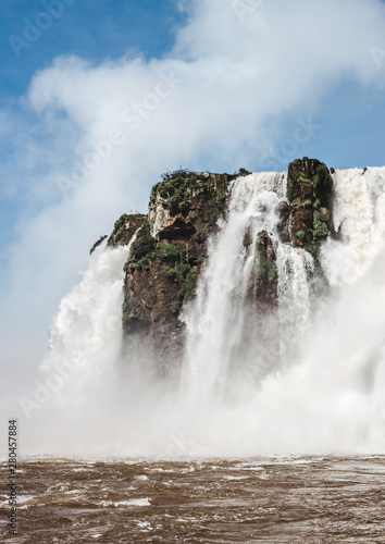 Powerful gushing water of Iguazu Falls  Argentina on a sunny day