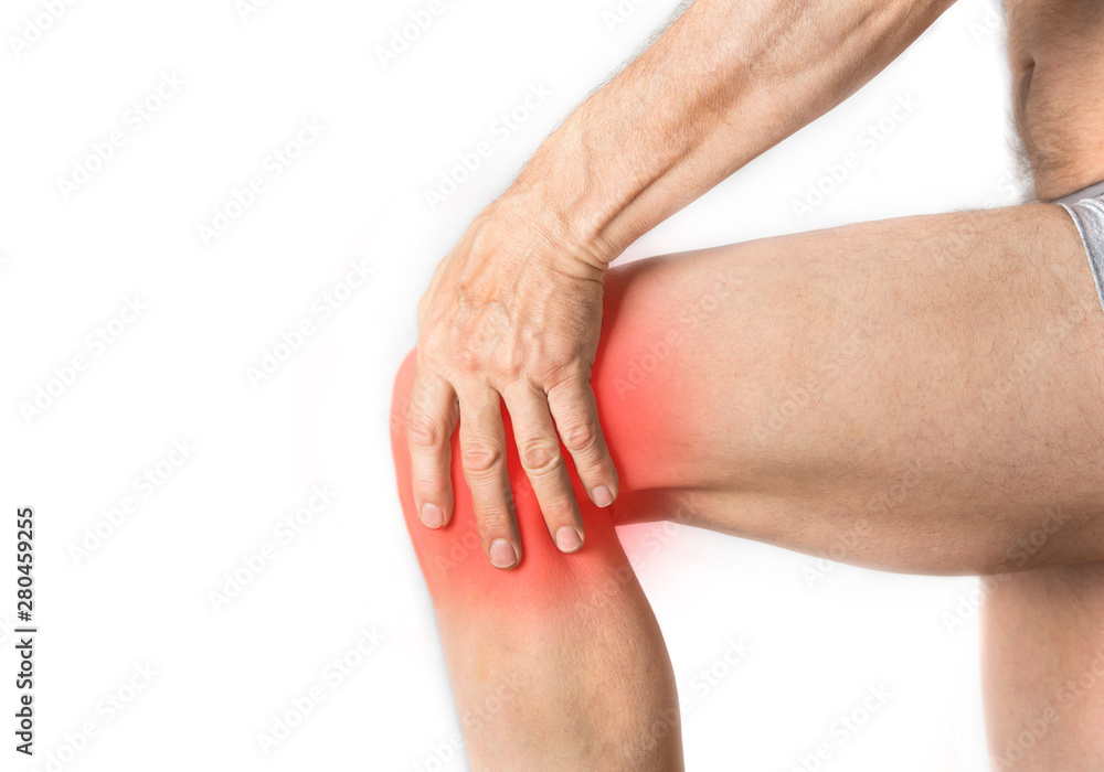 Man is holding his aching knee with a hand Man is holding his aching knee with a hand