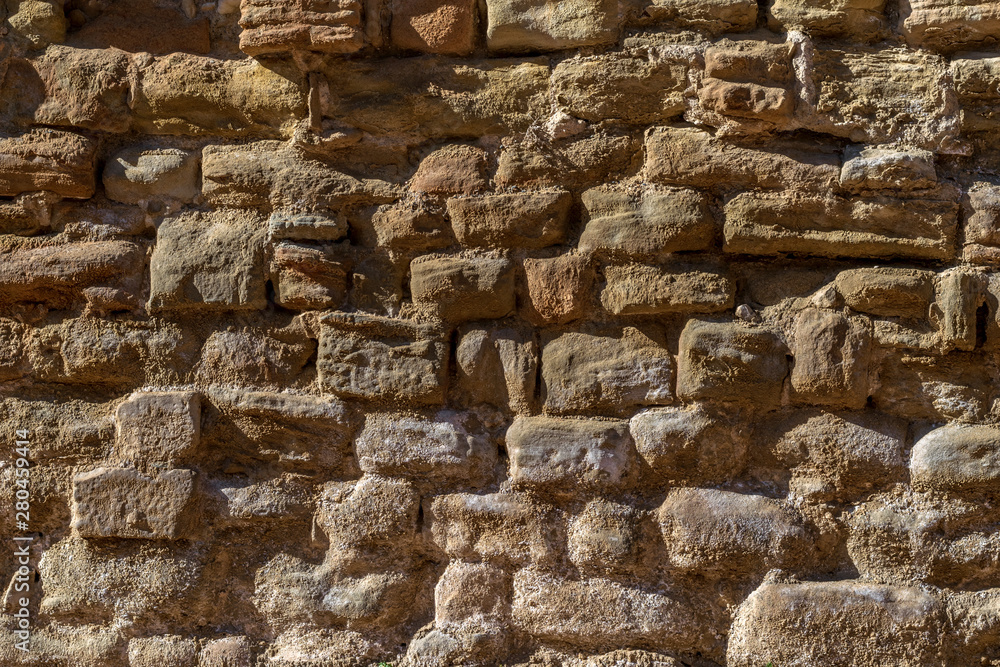 Background of the ancient stone wall of the castle in Spain.