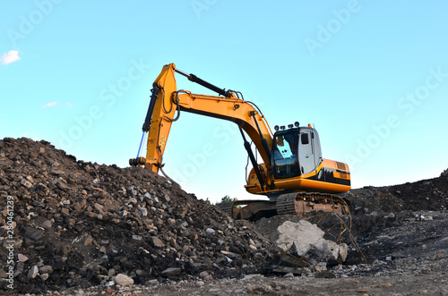 Excavator with crusher bucket for crushing concrete. Construction waste recycling for construction mix. Sifting and grinding bucket for the separation of concrete into fractions of higher quality.