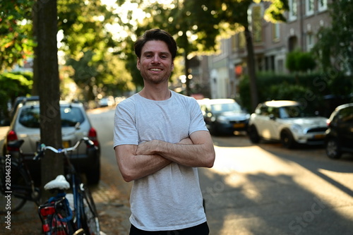 Photography Male master student smiling and standing with his arms crossed in a traditional