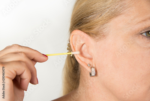 Woman cleaning her ear with a swab