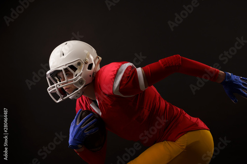Photo of running sportswoman with rugby ball, in white helmet