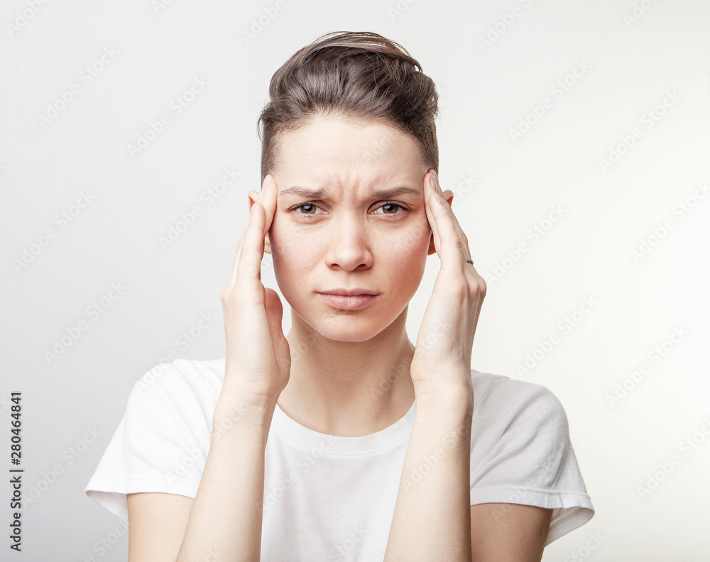 Young beautiful woman has headache, isolated on gray background. Young beautiful woman has headache, isolated on gray background.