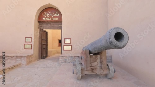 Nizwa Fort, Oman - February 2019. Traditional Omani fortress, general plan and details, guns and a flag on the main tower. photo