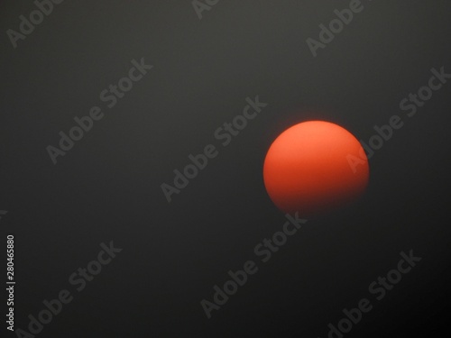 A reddish orange hazy summer sun © Abby Dorland