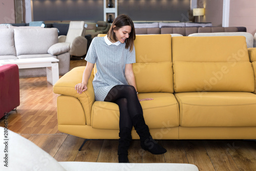 Woman sitting on yellow sofa