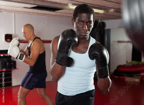 Potrait of african american boxer who is training in gym