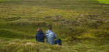 Couple sitting in the middle of the green moss field  in the summer in Iceland ,Travel vacation and summer time concept.