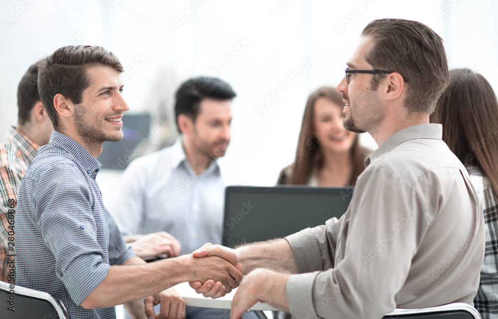 close up.the handshake between the Manager and the employee at the Desk close up.the handshake between the Manager and the employee at the Desk