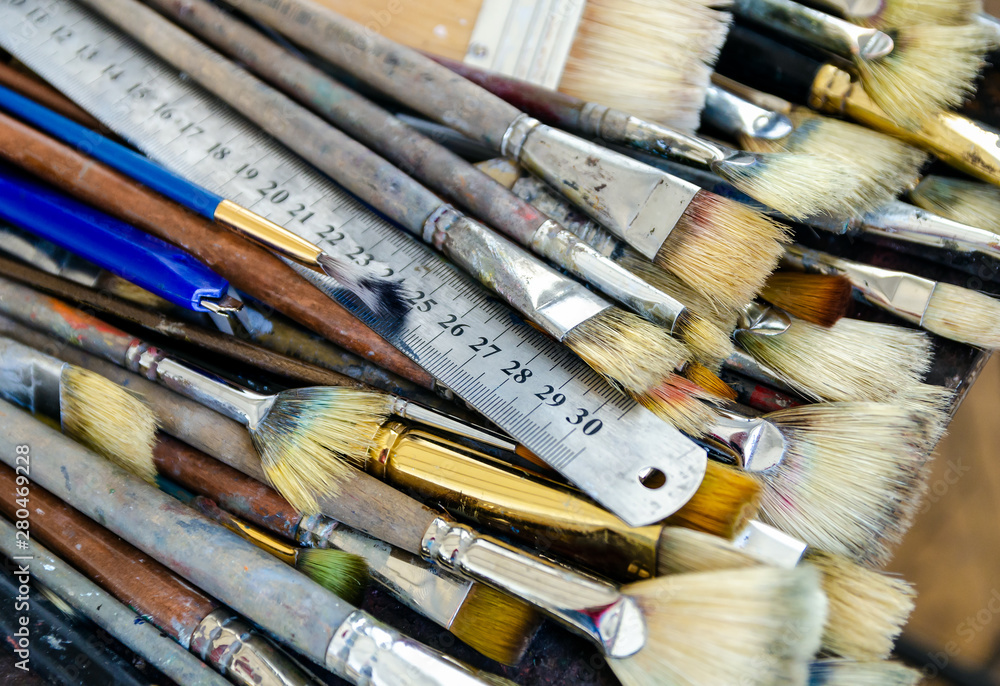 Obraz premium A metal ruler and set of different sizes brushes of the artist for oil painting