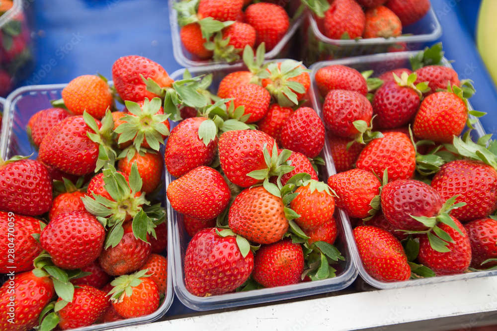 Red fresh strawberries in plastic boxes ready for sell at farmers marketplace Red fresh strawberries in plastic boxes ready for sell at farmers marketplace