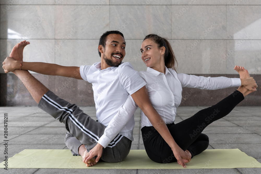 Ταπετσαρία loving couple masters different nationalities conducts yoga practice near business center