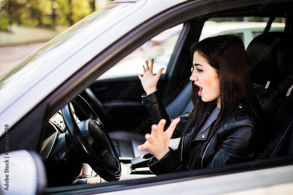 Dear in headlights. Fright face woman driving car wide open mouth eyes screaming squeezing wheel, side window view. Negative human face expression emotion reaction. Road trip risk danger concept