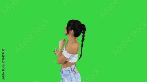 Girl dancing and aswering the call on the phone on a Green Screen, Chroma Key. photo