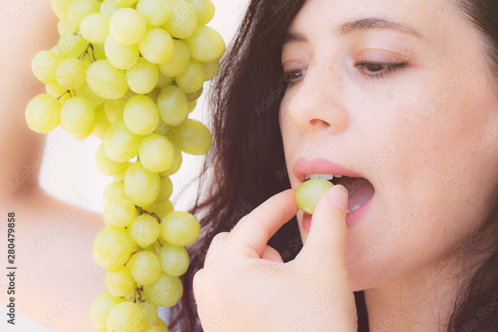 the beautiful girl is eating the green grapes the beautiful girl is eating the green grapes