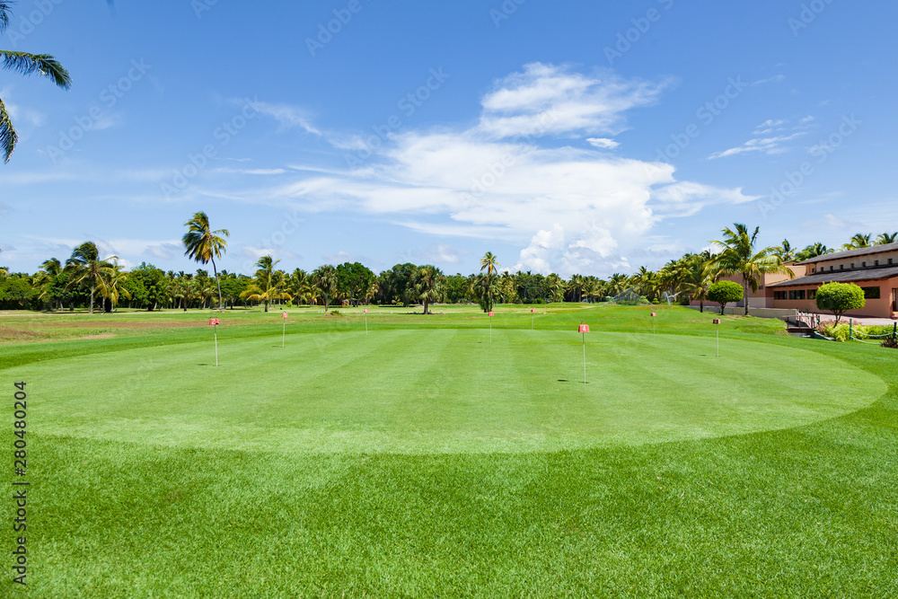 Panorama view of a golf course with installation green . Golf course with a rich green lawn in the countryside in summer day. beautiful scenery with a rich green turf and blue sky background 