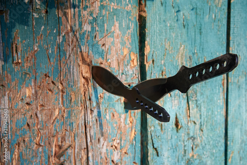 Knives for throwing different sizes in a wooden fence photo