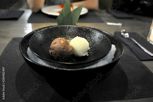 Ice cream in a black plate. Gourmet food in the restaurant. Healthy food. Close-up. Table setting © lkorotova