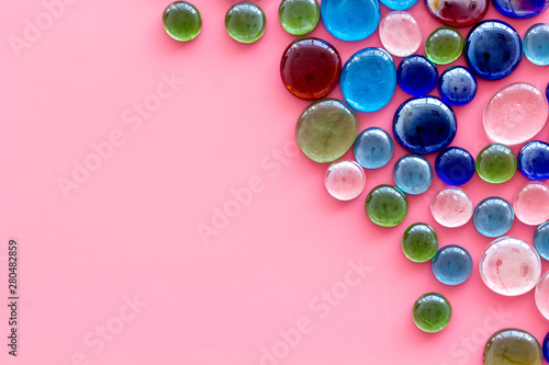 Glass stones for design and home creativity on pink background top view space for text
