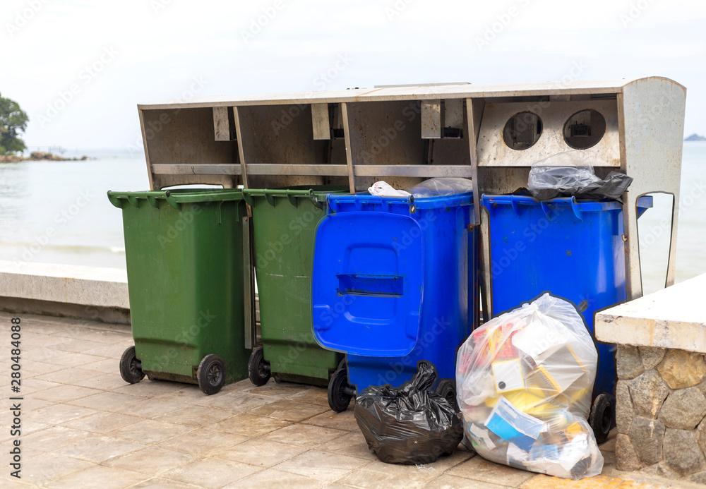 Green and blue bin for different collection Of Recycle Materials on footpath near beach Green and blue bin for different collection Of Recycle Materials on footpath near beach