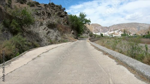paved road parallel to Nacimiento river approaching Alboloduy, province of Almeria, Andalusia, Spain photo