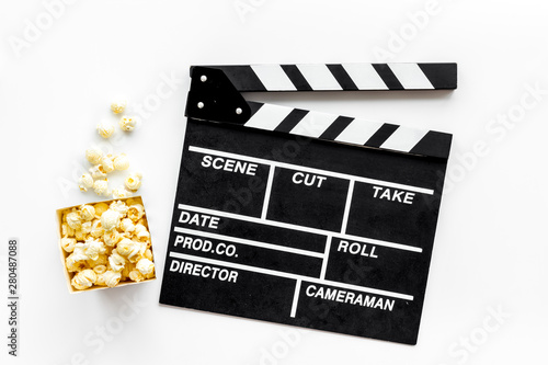 Go to the cinema with popcorn and clapperboard on white background top view