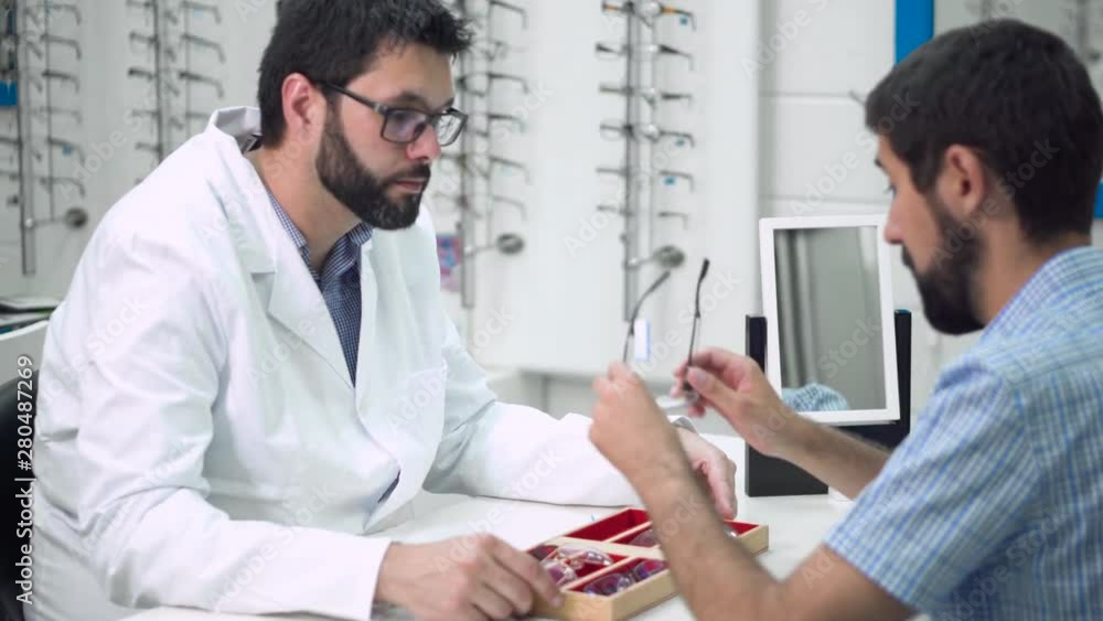 doctor ophthalmologist is helping a client to choose the most appropriate glasses in ophthalmologic clinic . doctor ophthalmologist is helping a client to choose the most appropriate glasses in ophthalmologic clinic .