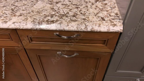 Kitchen cabinet drawer closing in slow motion. Kitchen cabinets are made of natural wood maple in red wood color stain photo