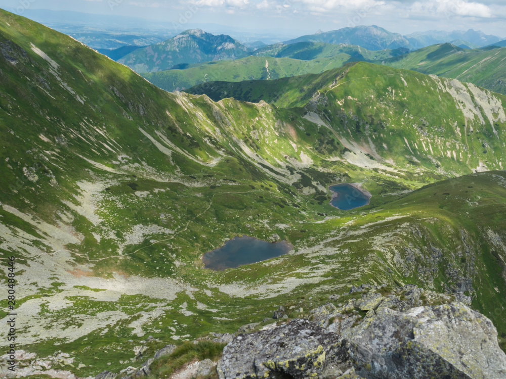 Beautiful vivid blue mountain lakes Horne and Dolne Jamnicke pleso with green mountain peaks view from the Jamnice sedlo saddle, Western Tatras mountains, Rohace Slovakia, summer sunny day blue sky