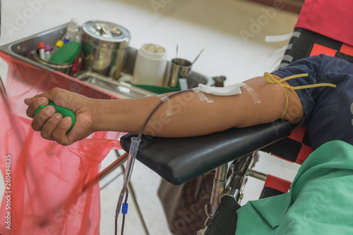 Blood donor at donation with a green bouncy ball holding in hand.