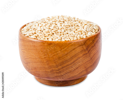 Raw quinoa seeds in wooden bowl.