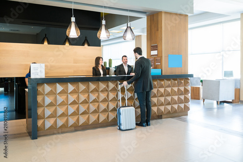Canvas Print Happy Hotel Clerks Are Welcoming Professional At Counter